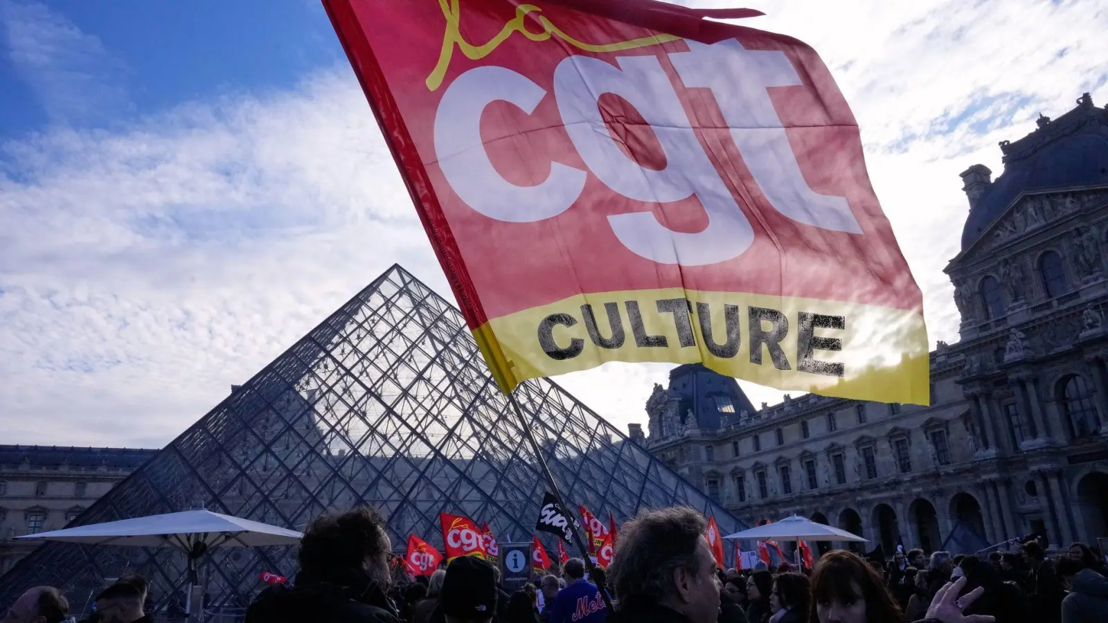 Angestellte zeigen eine Flagge der Gewerkschaft CGT vor dem Louvre, nachdem sie für einen Streik gestimmt haben. (Foto: Michel Euler/AP/dpa)