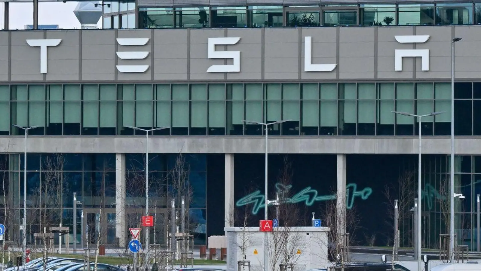 Nur wenige Autos von Mitarbeitern der Tesla-Gigafactory Berlin-Brandenburg stehen vor dem Werk. (Foto: Patrick Pleul/dpa)