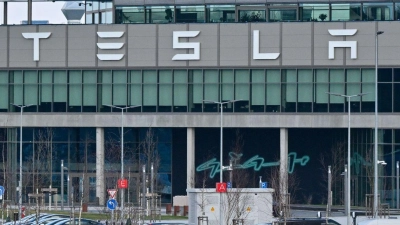 Nur wenige Autos von Mitarbeitern der Tesla-Gigafactory Berlin-Brandenburg stehen vor dem Werk. (Foto: Patrick Pleul/dpa)