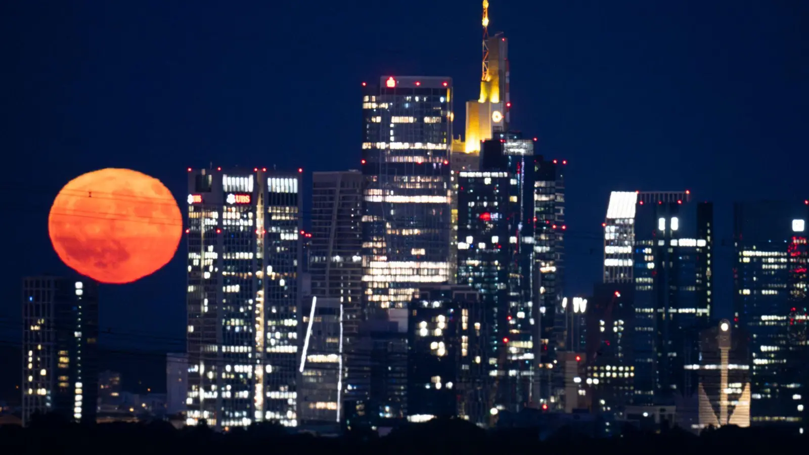In Frankfurt reihte sich der Erdbeermond in die Skyline ein. (Foto: Boris Roessler/dpa)