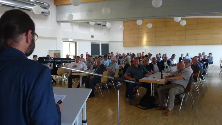 Gunter Schramm (links) vom Planwerk erläutert den Anwesenden in der Schulturnhalle Dietenhofens die neuesten Details zur LAG Rangau. (Foto: Florian Pöhlmann)