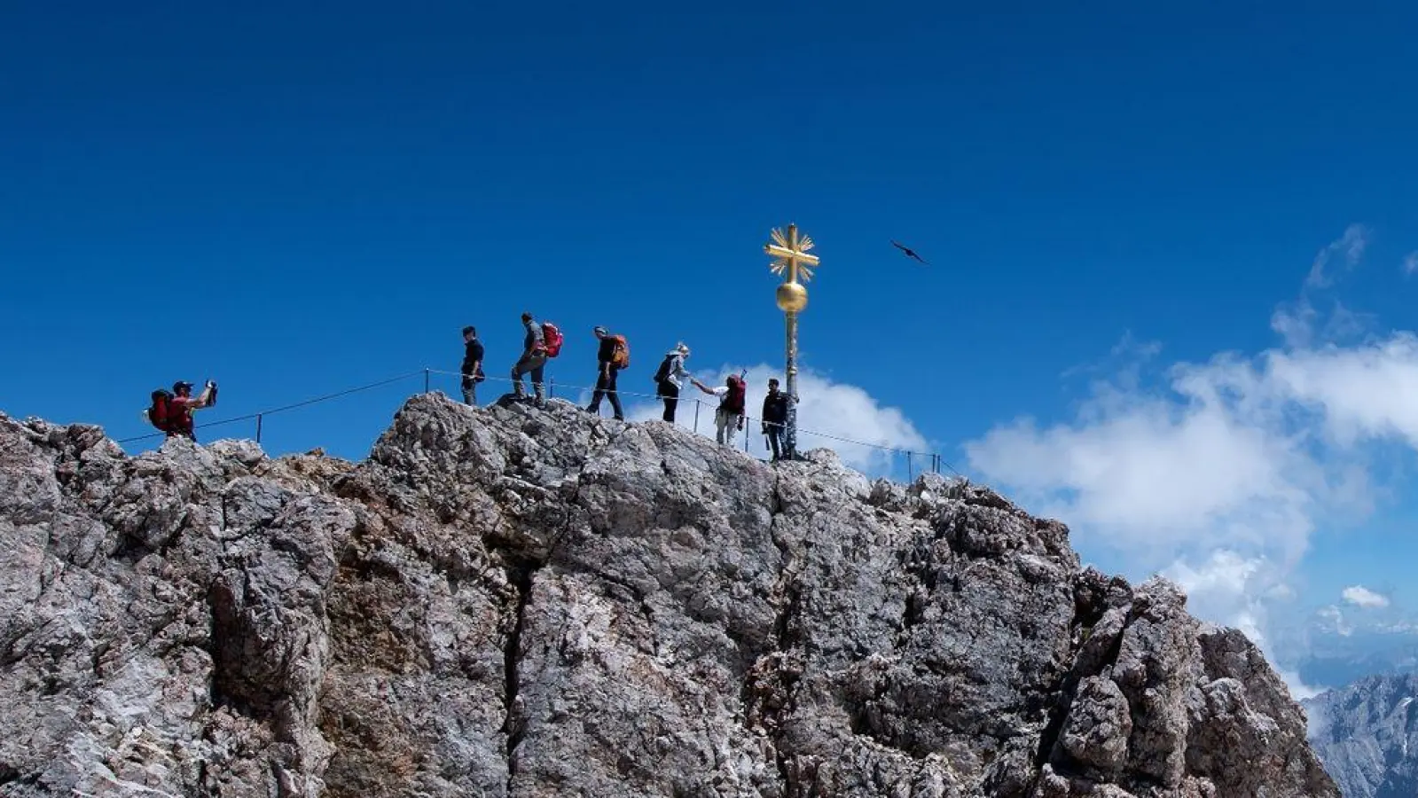 Bergsteiger am Gipfelkreuz der Zugspitze: In dieser Höhe (2962 m) braucht der Körper schon etwas länger, um sich anzupassen. (Foto: Sven Hoppe/dpa)