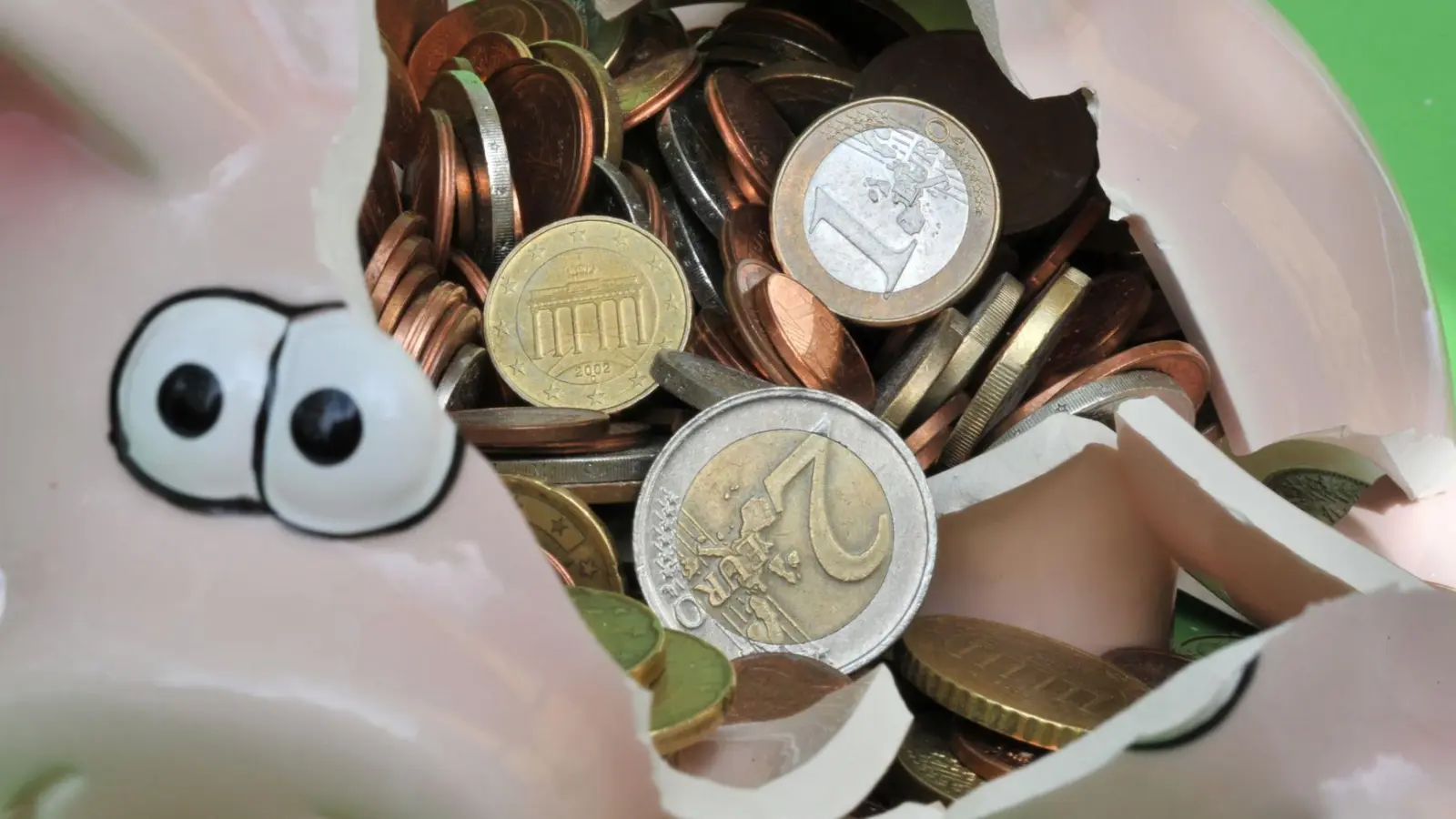 Ein zerbrochenes Sparschwein mit Euromünzen. (Foto: Peter Kneffel/dpa)