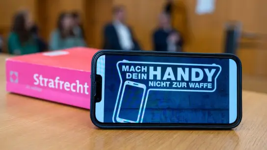 „Mach dein Handy nicht zur Waffe“ steht auf dem Display eines Smartphones im Amtsgericht. (Foto: Armin Weigel/dpa)