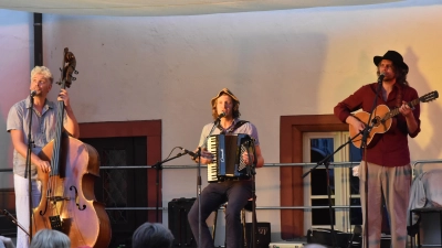 Die Kapelle Bomhard bot den rund hundert Gästen im Neustädter Schlosshof zwei Stunden lang ihre neue, moderne Volksmusik im fränkischen Dialekt. Georg Bomhard hat Kontrabass studiert, Heiner Bomhard Schauspiel und Johannes Bomhard Schulmusik (von links). (Foto: Anita Dlugoß)