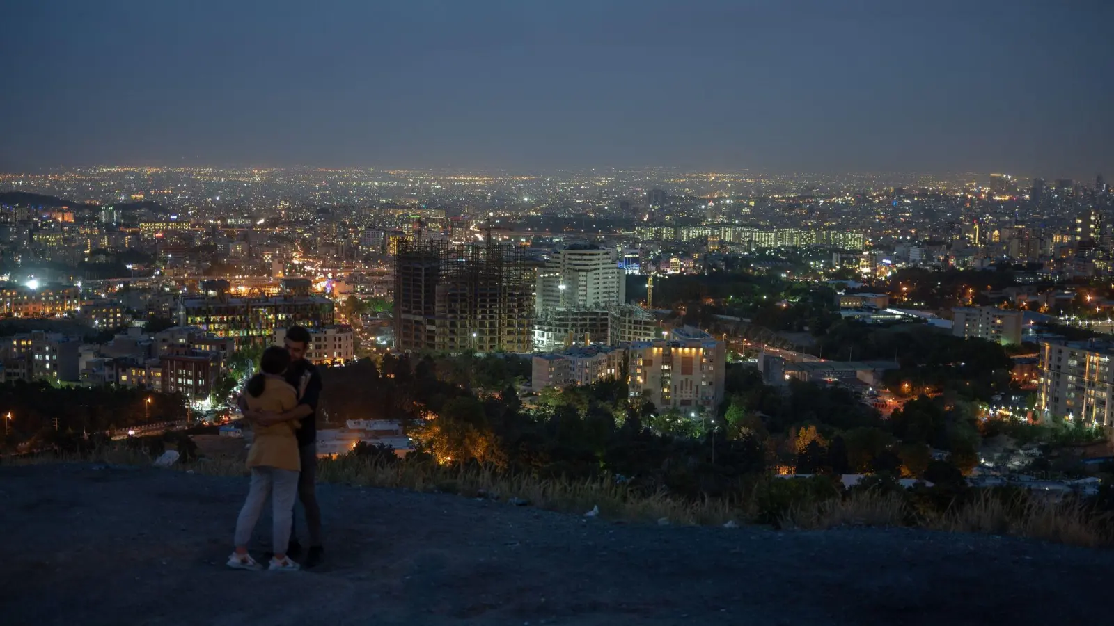 Ein junges Paar vor der Teheraner Skyline nach Sonnenuntergang. (Foto: Arne Bänsch/dpa)