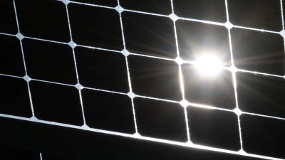 Die Sonne scheint durch die Solarzellen einer Solaranlage. (Foto: Patrick Seeger/dpa/Archivbild)