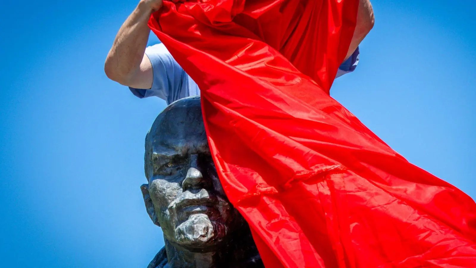 Vertreter von Opferverbänden verhüllen bei einer Kundgebung in Schwerin eines der letzten Lenin-Denkmäler in Deutschland und protestieren damit gegen die öffentlichen Ehrungen der Repräsentanten von Systemen der Gewaltherrschaft. (Foto: Jens Büttner/dpa)