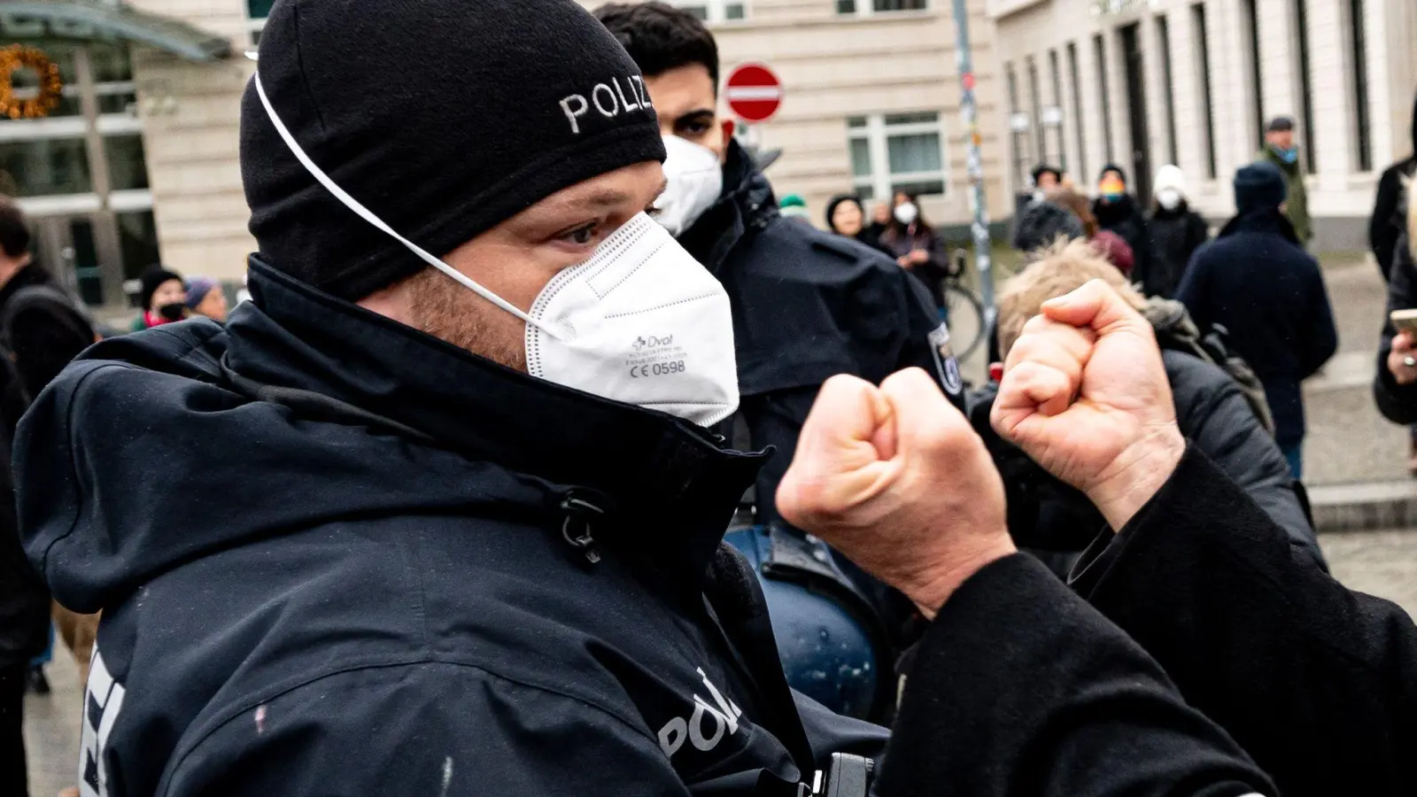 Ein Demonstrant zeigt einem Polizisten die Fäuste. (Foto: Fabian Sommer/dpa/Symbolbild)