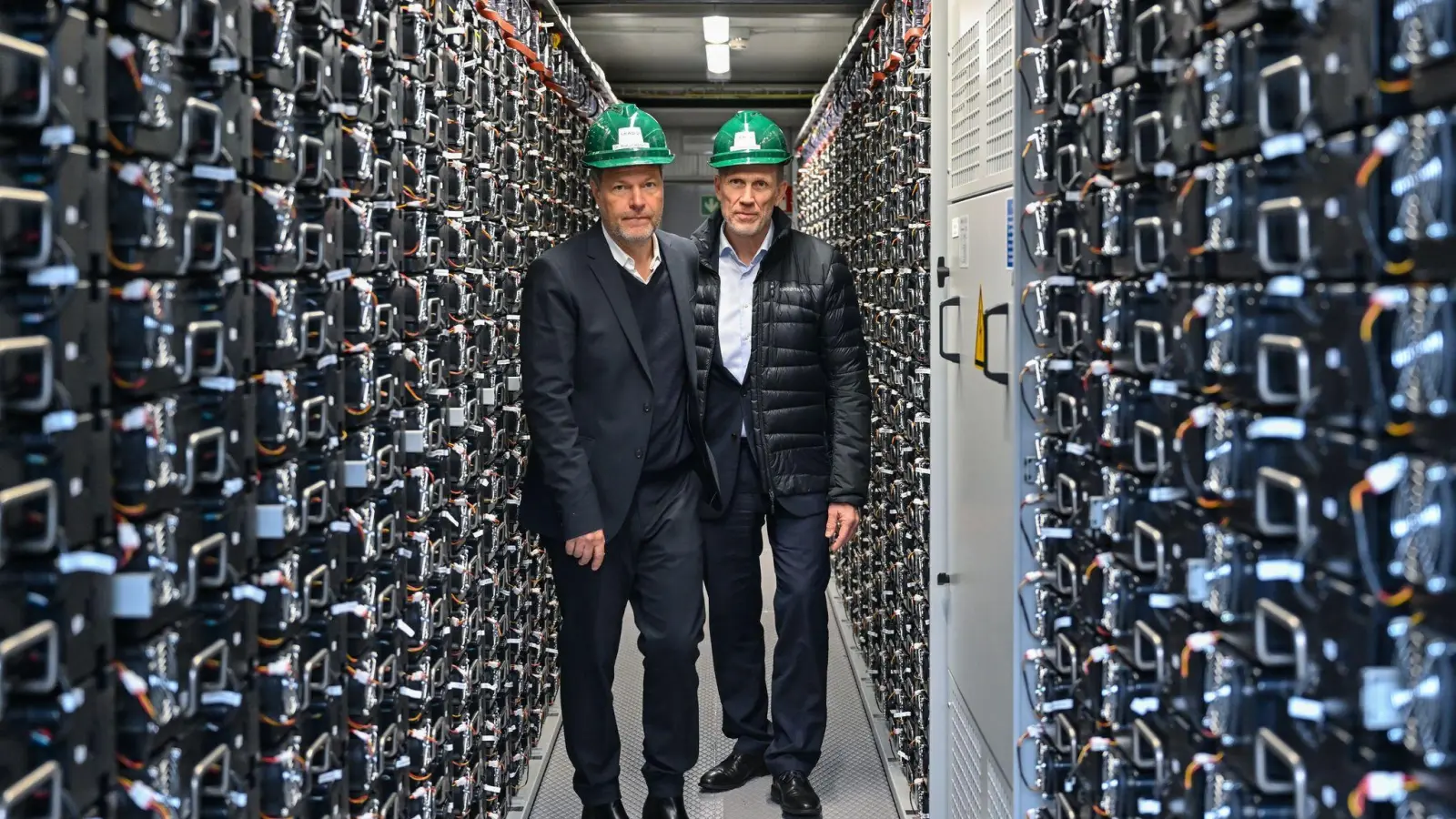 Bundeswirtschaftsminister Robert Habeck (l) und Leag-Chef Thorsten Kramer besuchen bei einem Rundgang über das Gelände des Braunkohlekraftwerks Schwarze Pumpe einen Batteriespeicher. (Foto: Patrick Pleul/dpa)