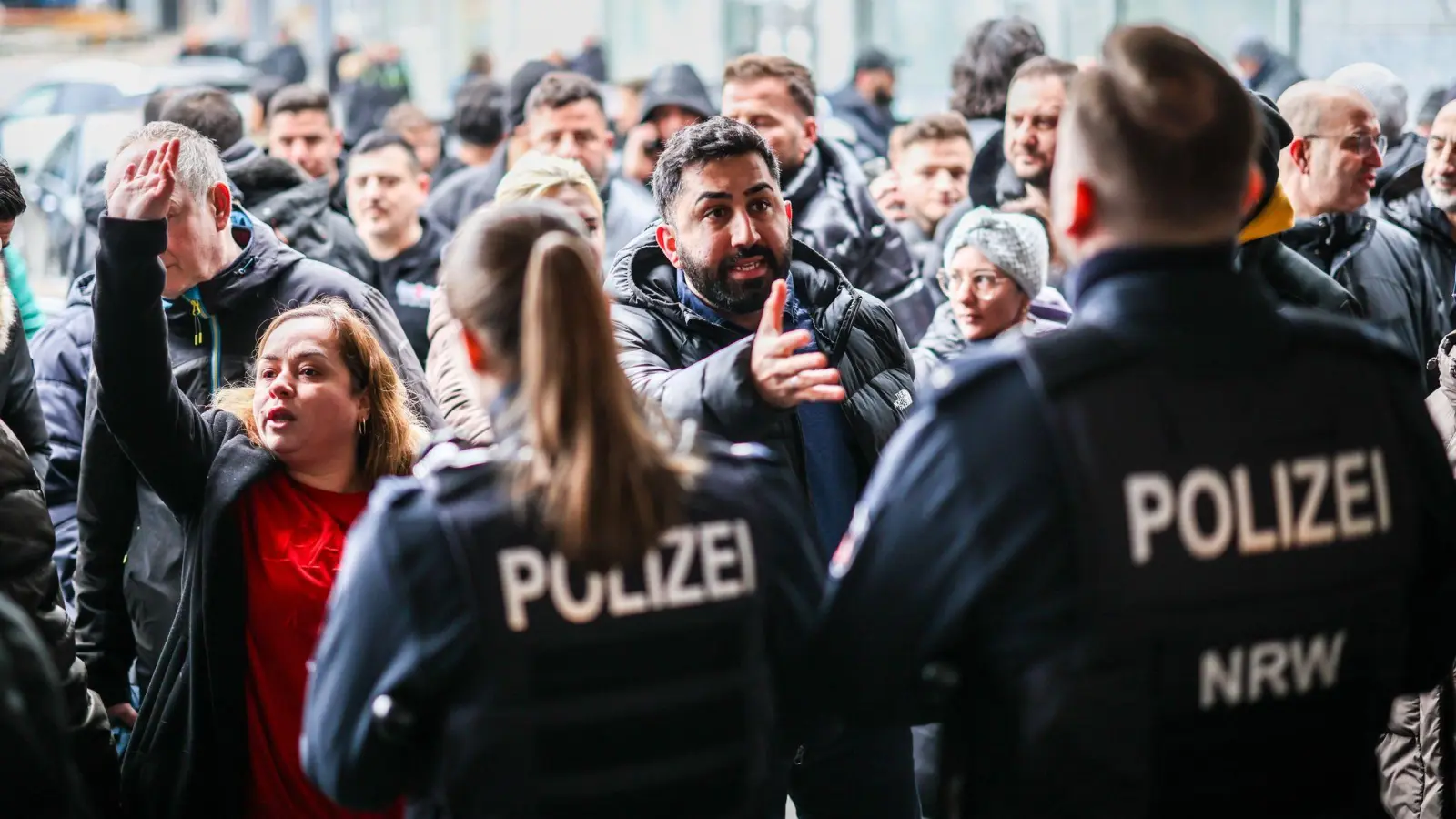 Aufgebrachte Kunden diskutieren vor der Sparkassenfiliale mit Polizeibeamten (Archivfoto) (Foto: Christoph Reichwein/dpa)