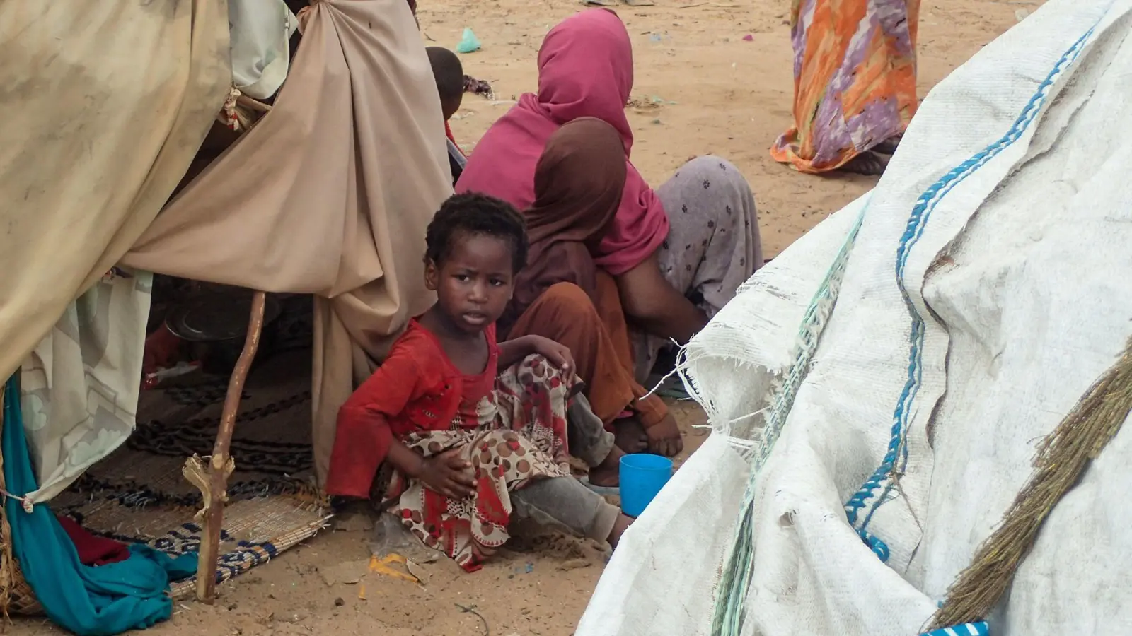 Von der Dürre betroffene Menschen sitzen vor einer Hütte im Lager für Binnenflüchtlinge Al-Hidaya am Rande von Mogadischu. (Foto: Mohamed Odowa/dpa)