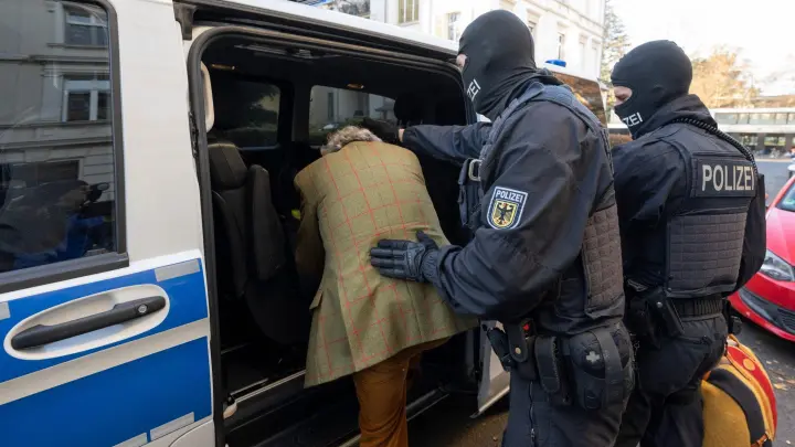 Bei einer Razzia gegen sogenannte „Reichsbürger“ in Frankfurt/Main führen vermummte Polizisten Heinrich XIII Prinz Reuß ab. (Foto: Boris Roessler/dpa)