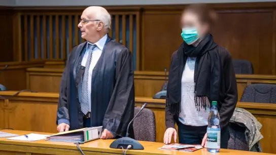 Die Frau, die ihre beiden Töchter von einem Balkon geworfen haben soll und anschließend selbst hinterher sprang, steht neben ihrem Anwalt Walter Teusch im Landgericht Saarbrücken. (Foto: Oliver Dietze/dpa)