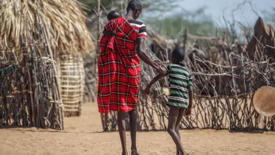 Ein Vater hilft seinem unterernährten Sohn beim Gehen in der Nähe ihrer Hütte in dem Dorf Lomoputh im Norden Kenias. Die Hungerkrise in der Welt spitzt sich dramatisch zu. (Foto: Brian Inganga/AP/dpa)