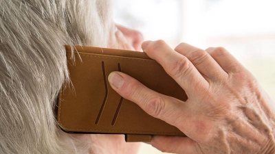 Eine Seniorin telefoniert mit ihrem Smartphone. (Foto: Sebastian Gollnow/dpa)