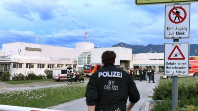 Polizisten und Einsatzkräfte der Feuerwehr stehen vor der abgeriegelten Notaufnahme des Unfallklinikums Murnau. (Foto: Karl-Josef Hildenbrand/dpa)