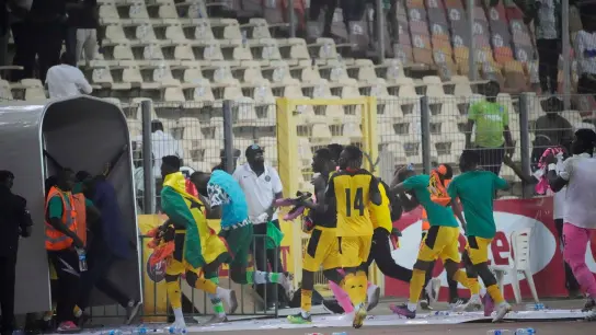 Ghanas Spieler rennen bringen sich nach dem Spiel in Abuja in Sicherheit. (Foto: Sunday Alamba/AP/dpa)