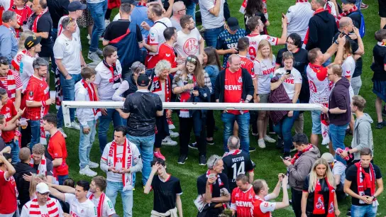 Kölner Fans halten nach einem Platzsturm einen Torpfosten. (Foto: Rolf Vennenbernd/dpa)