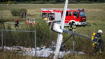 Trümmerteile eines Flugzeugs hängen in einem Zaun. (Foto: Pia Bayer/dpa)