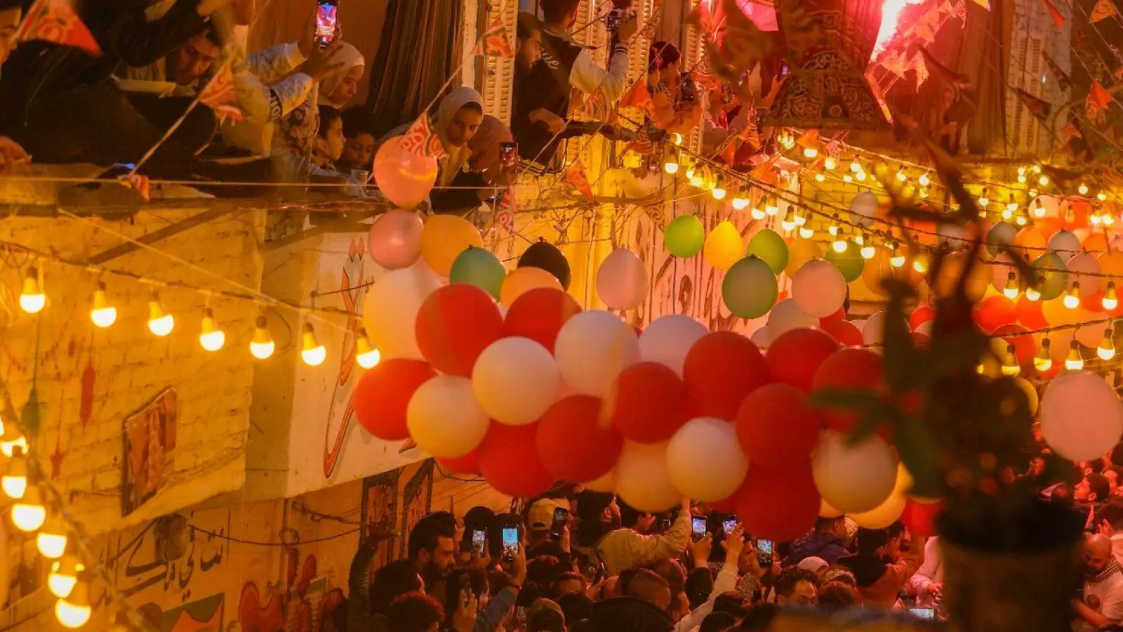 Bewohner Kairos zünden Fackeln an, während sie im Rahmen des heiligen Fastenmonats Ramadan das „Iftar“, die Mahlzeit zum Fastenende bei Sonnenuntergang, feiern. (Foto: Amr Nabil/AP/dpa)