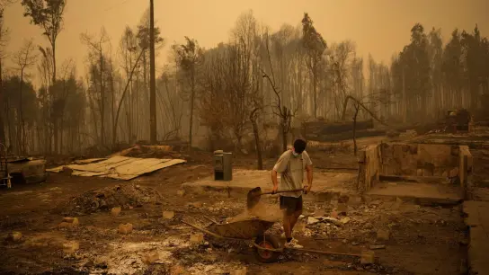 Ein Mann beseitigt die Trümmer seines durch Waldbrände zerstörten Hauses in Santa Juana in Chile. Die Zahl der Toten bei verheerenden Waldbränden im Süden des Landes ist auf 23 gestiegen. (Foto: Matias Delacroix/AP/dpa)