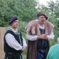 Waldemar von den Greifen (Steve Sträßer, links) und Dieterich von Hohenforst (Max Wechsler, mit Fellmantel, rechts) besprechen sich gerade, wie sie der Heilerin Afra den Mord an der Magd Hanni in die Schuhe schieben können.  (Foto: Martina Hinkelmann)