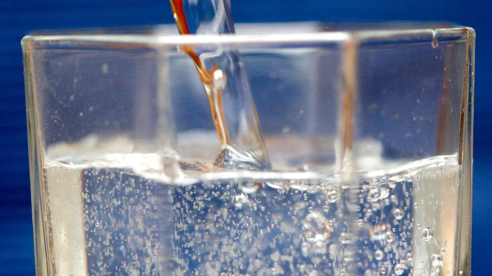 Mineralwasser wird in ein Wasserglas gegossen. (Foto: Roland Weihrauch/dpa/Symbolbild)