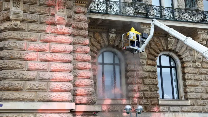 Mit einem Dampfstrahler wird die Fassade des Hamburger Rathauses gereinigt. (Foto: Bodo Marks/dpa)