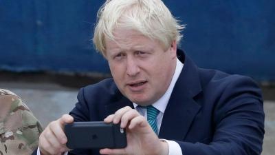 Die Nachrichten auf dem Handy von Boris Johnson sind von großem Interesse. (Foto: Sunday Alamba/AP/dpa)