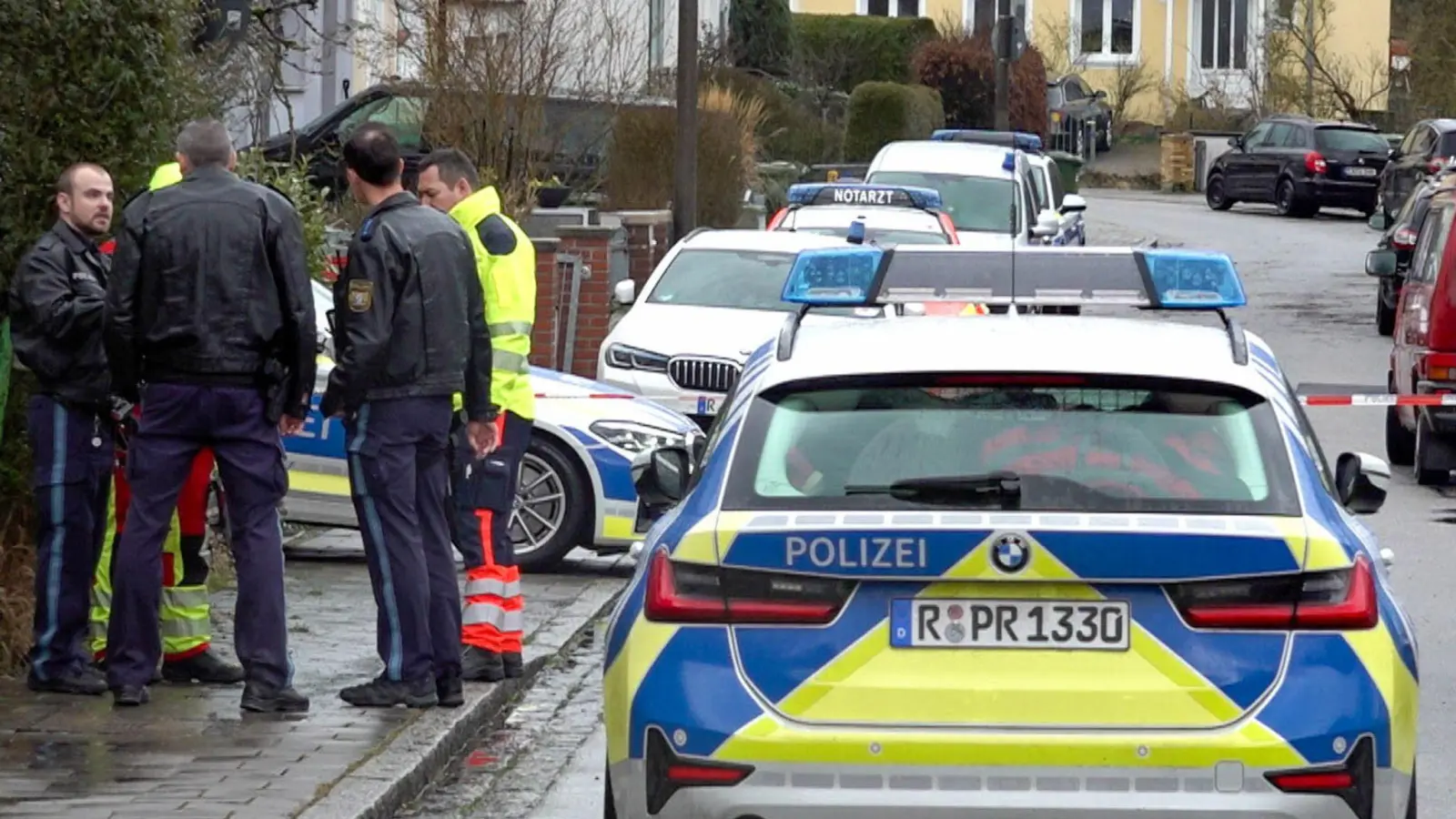 Polizei und Notarzt stehen vor dem Haus in Regensburg, in dem sich die Gewalttaten ereigneten. (Foto: Tiedemann/vifogra/dpa)