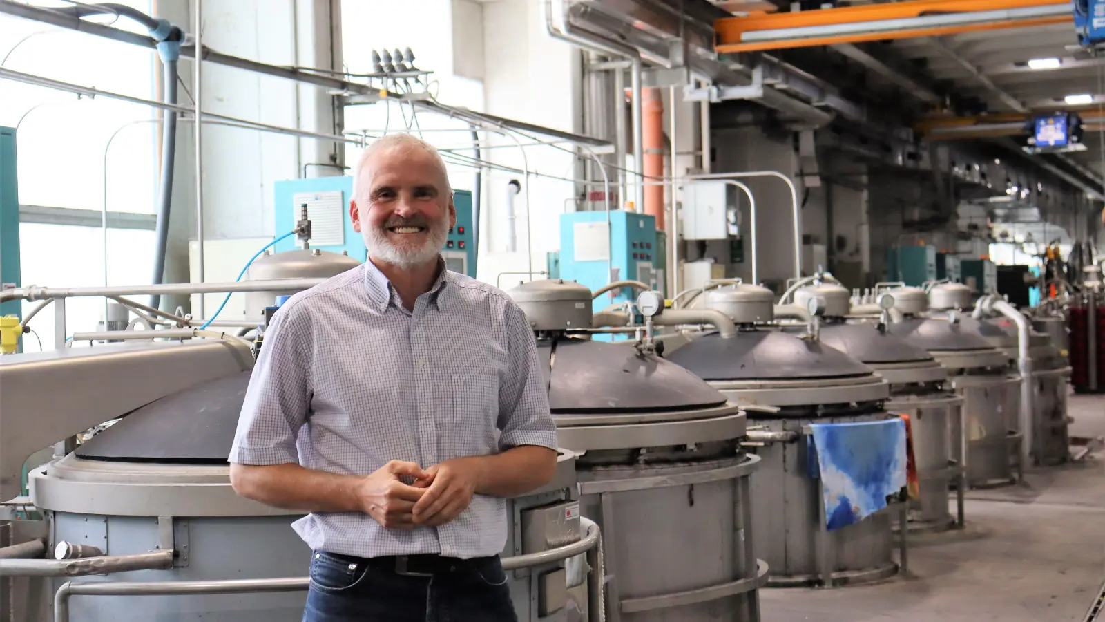 In den Kesseln hinter Klaus Christ wird das Garn gefärbt und getrocknet. (Foto: Antonia Müller)