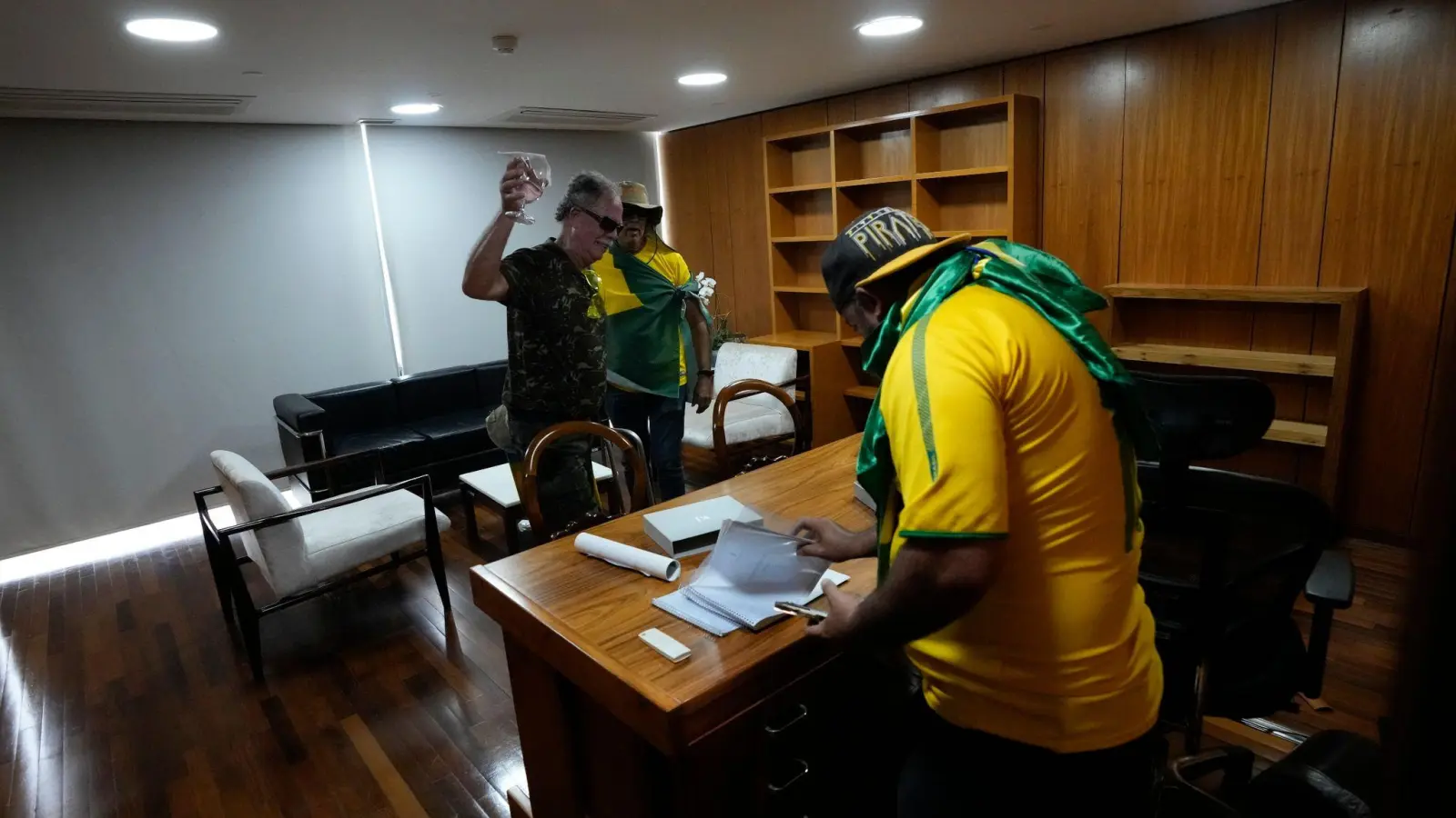 Bolsonaro-Anhänger wühlen sich in einem Büro des Palacio do Planalto, dem offiziellen Sitz des brasilianischen Präsidenten, durch Papiere. (Foto: Eraldo Peres/AP/dpa)
