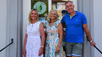 Doris (Mitte) und Roland Hauenstein stehen vor den Türen der Markgrafen-Apotheke, die sie zwei Jahrzehnte lang geführt haben. Carole Holzhäuer (links) wird diese ab dem 1. Juli übernehmen. (Foto: Irmeli Pohl)