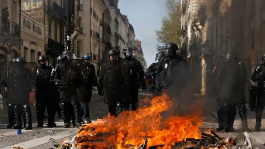 Bereitschaftspolizisten hinter einer brennenden Barrikade in Nantes. (Foto: Jeremias Gonzalez/AP/dpa)