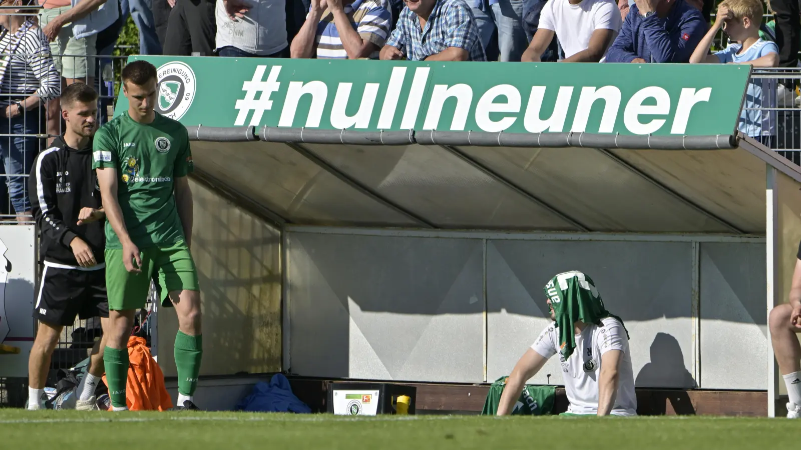 Im letzten Heimspiel gegen Burghausen plagte so manchen Ansbacher schon die Sonne, Lukas Oberseider (in Grün) wurde von Coach Niklas Reutelhuber (links) aber nochmal aufs Feld geschickt. (Foto: Martin Rügner)