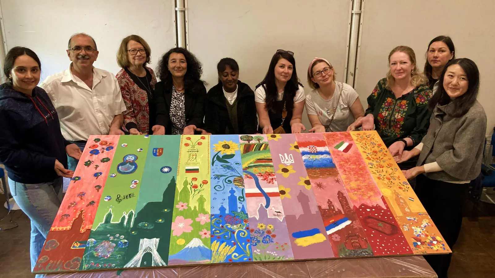 Dieses Kunstwerk entstand gestern im Laufe des Festes. Die Stadtsilhouette wird umrahmt von den vielen Nationalitäten, die in Rothenburg leben. Eine ganze Reihe an Leuten hat bei der Aktion mit Künstler Moneer Ballish (Zweiter von links) mitgemacht. Das Bild soll in der Stadtbücherei aufgehängt werden. (Foto: Clarissa Kleinschrot)