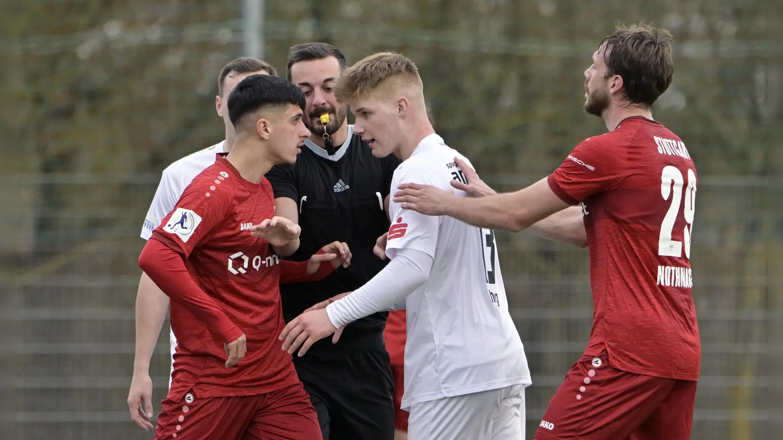 Wehrt sich auf dem Platz, auch mit Worten: Der Ansbacher Nachwuchsspieler Finn Haag (weißes Trikot) bespricht sich mit dem Stuttgarter Jannis Boziaris. Schiedsrichter Patrick Höfer schlichtet, rechts der Stuttgarter Dominik Nothnagel. (Foto: Martin Rügner)