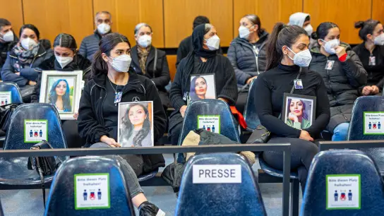 Angehörige der Getöteten sitzen mit Porträtfotos der Frau beim Prozessauftakt in einem Saal vom Landgericht Hildesheim. Auch am zweiten Verhandlungstag wurden viele Bilder mitgebracht. (Foto: Moritz Frankenberg/dpa)