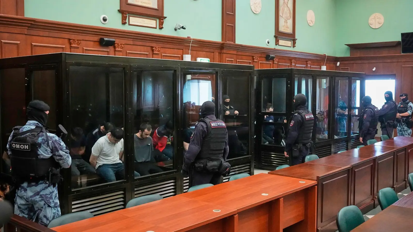 Die 19 Angeklagten saßen schwer bewacht in gläsernen Käfigen.  (Foto: Pavel Bednyakov/AP/dpa)