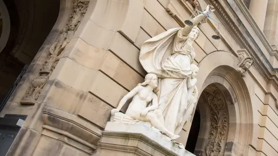 Vor einem Landgericht hält eine Statue der Justitia eine Waagschale. (Foto: Stefan Puchner/dpa/Symbolbild)