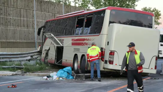 Der verunglückte Bus steht auf der Westautobahn bei Eugendorf an der beschädigten Leitplanke. (Foto: Franz Neumayr/APA/dpa)