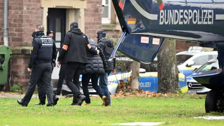 Beim Bundesgerichtshof in Karlsruhe wird eine Person von Polizisten aus einem Hubschrauber gebracht. (Foto: Uli Deck/dpa)