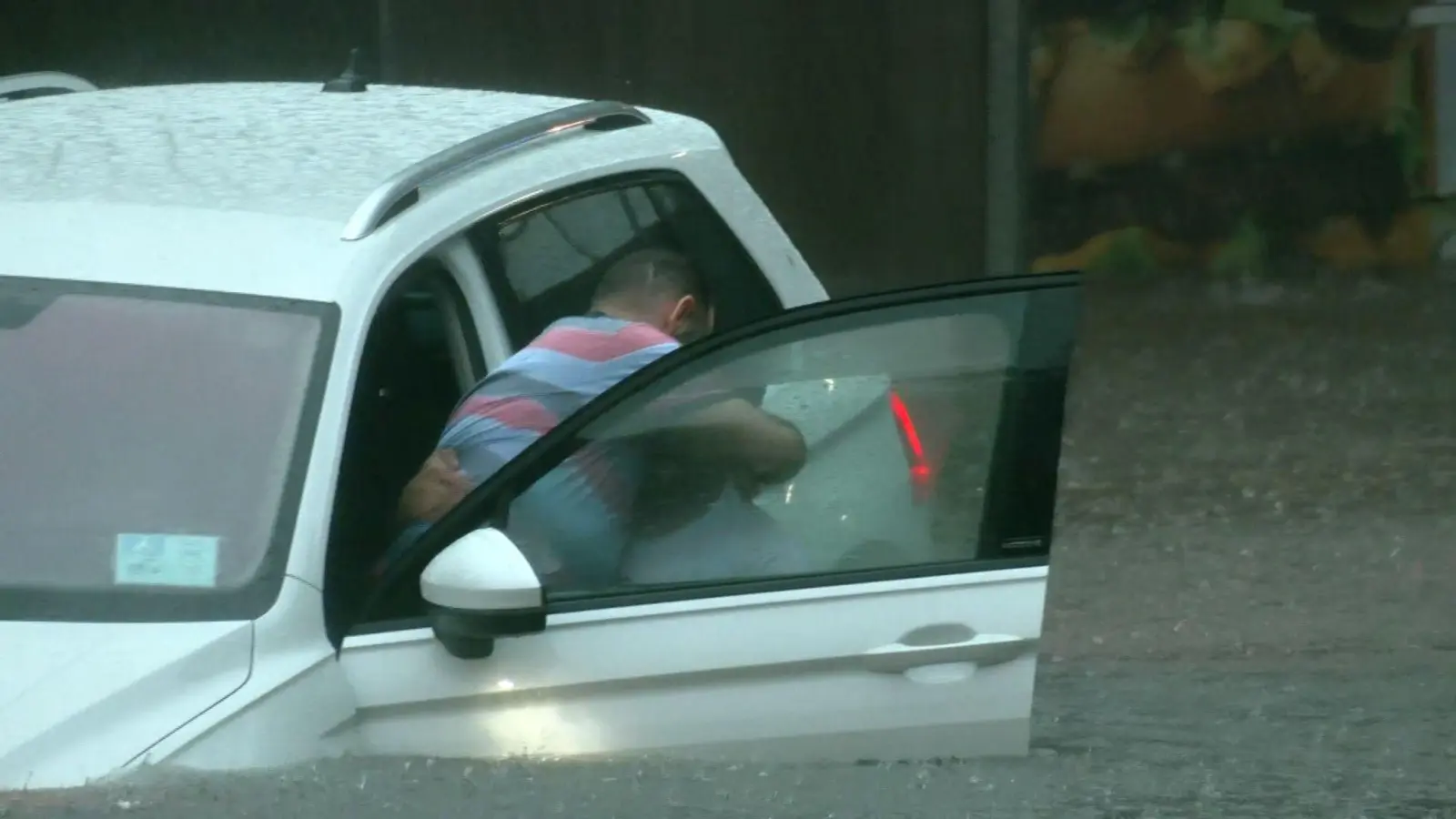 Ein Mann versucht, sich in einer Unterführung aus dem Auto zu befreien. (Foto: Oßwald/News5 /dpa)