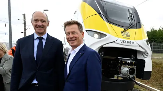 Roland Busch (l), Vorstandsvorsitzender von Siemens, und Richard Lutz, Vorstandsvorsitzender der Deutschen Bahn, stehen vor einem neuartigen Wasserstoffzug. (Foto: Roberto Pfeil/dpa)