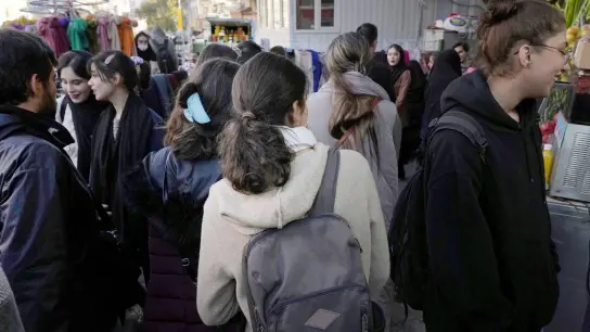 Iranische Frauen gehen ohne ihr vorgeschriebenes islamisches Kopftuch zu tragen durch Teheran. (Foto: Vahid Salemi/AP/dpa)