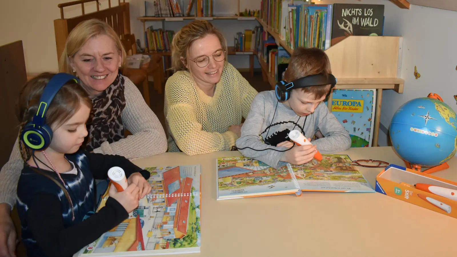 Sprachfachkraft Nina Wolf (rechts) und Kita-Leiterin Kerstin Müller probierten mit Felix und Calotto einmal die Tiptoi-Bücher aus, mit denen viele Themen spielerisch erforscht werden können. (Foto: Ute Niephaus)