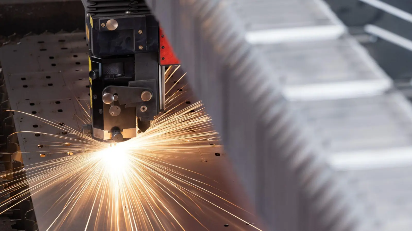 Eine Metallplatte wird in einer Produktion bearbeitet. (Foto: Hendrik Schmidt/dpa/Symbolbild)