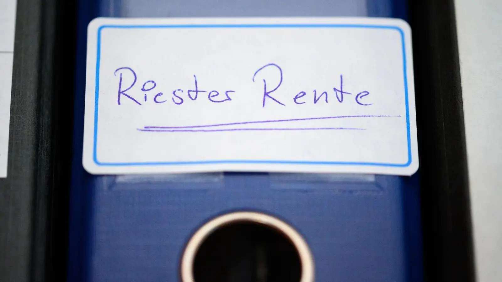 Ein Ordner mit einem Aufkleber „Riester-Rente“ steht in einem Regal. (Foto: Jonas Walzberg/dpa)