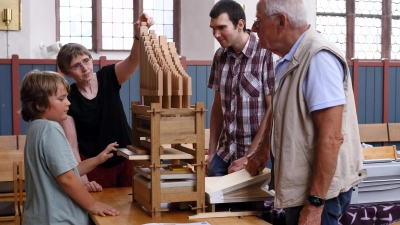 Nach getaner Arbeit bei der Orgelprobe (von links): Yannik Meyer, Ulrike Walch, Adrian Bayer und Götz Alber bringen das kleine Bausatz-Instrument zum Klingen. (Foto: Thomas Wirth)